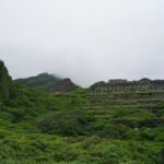 Abandoned ruins in misty green hills, a scenic view perfect for exploration.