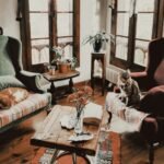 A warm living room featuring cats on vintage armchairs and rustic decor.