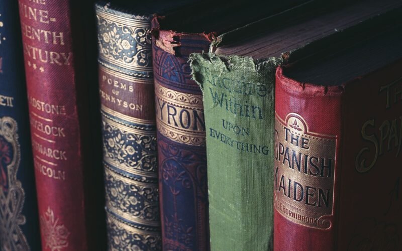 Close-up of vintage hardcover books showcasing ornate book jackets and titles.
