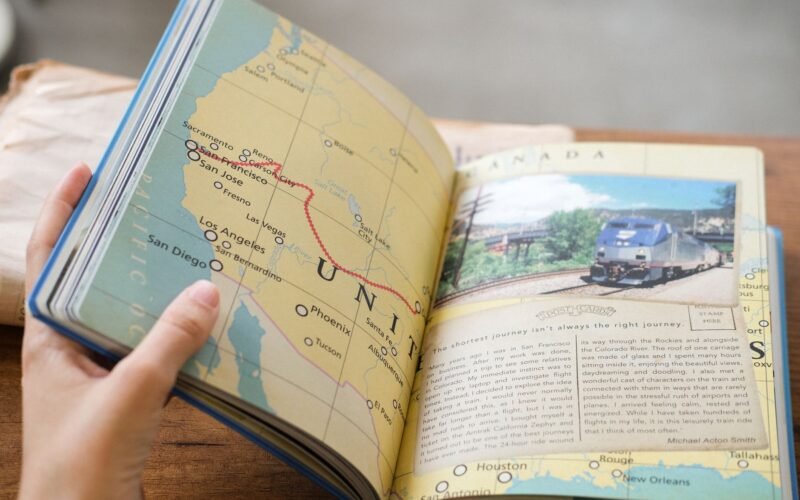 Close-up of a book showing a USA map with West Coast train routes and a train photo.