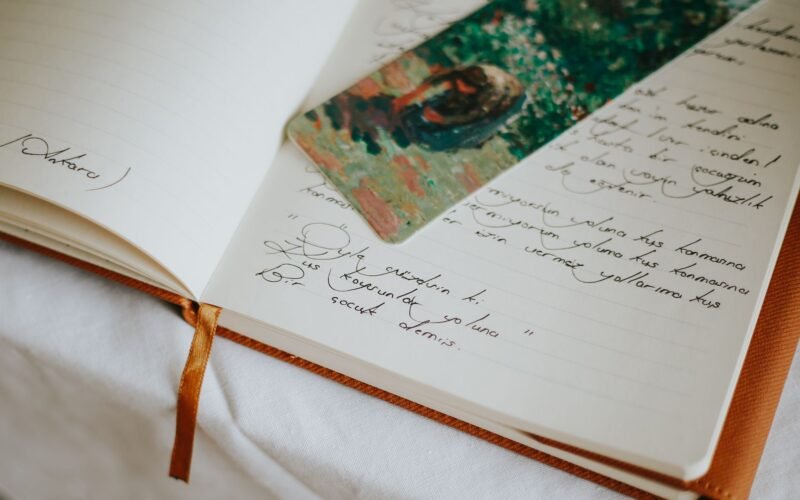 A close-up of an open journal with handwritten text and a colorful bookmark, evoking creativity.