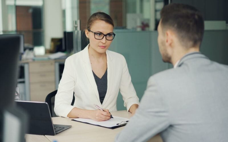 Two professionals in a serious business meeting at a modern office setting.