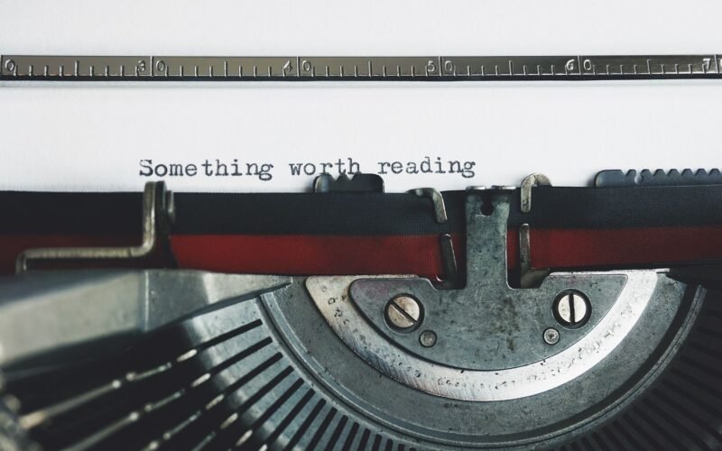 Close-up of a vintage typewriter with the phrase 'Something worth reading'.